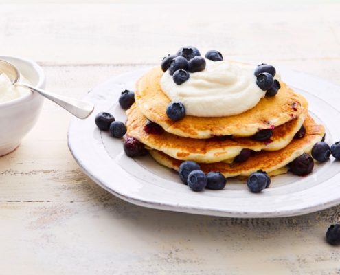pancakes with kefir and blueberry topping on a white plate