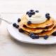pancakes with kefir and blueberry topping on a white plate