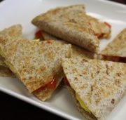 whole wheat breakfast quesadilla toasted and cut in triangle and placed on a while plate